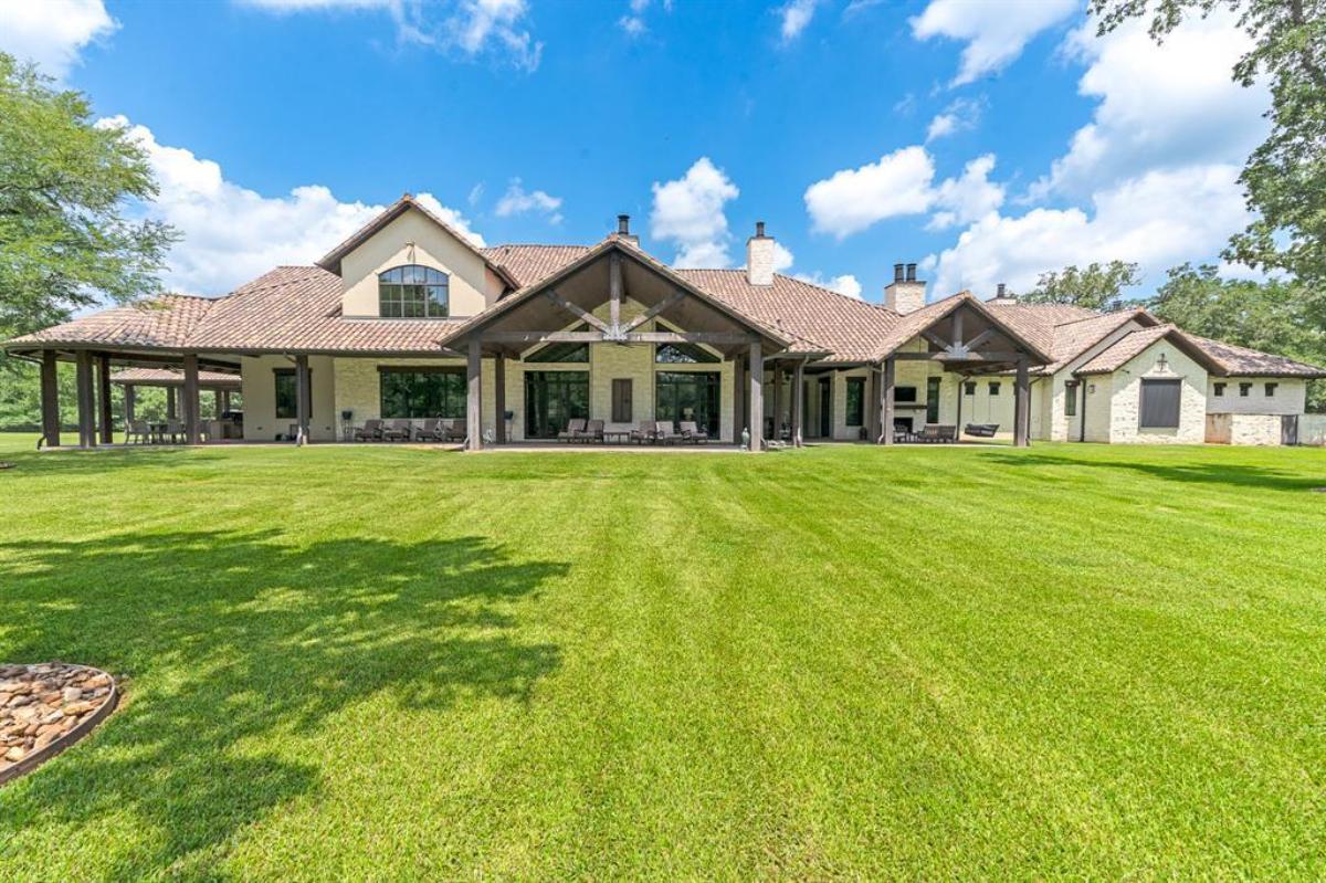Rear view of the mansion with a large green lawn.