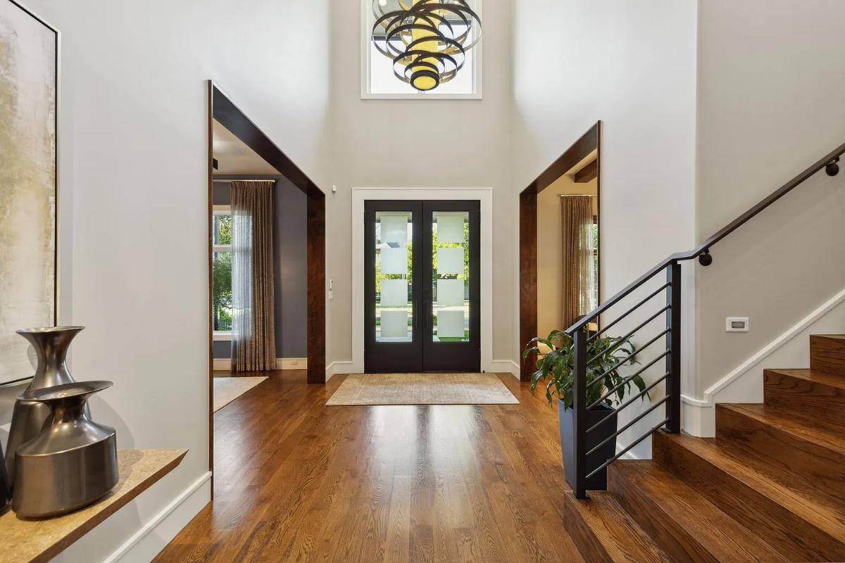 Foyer with glass/ wood doors and high ceilings.