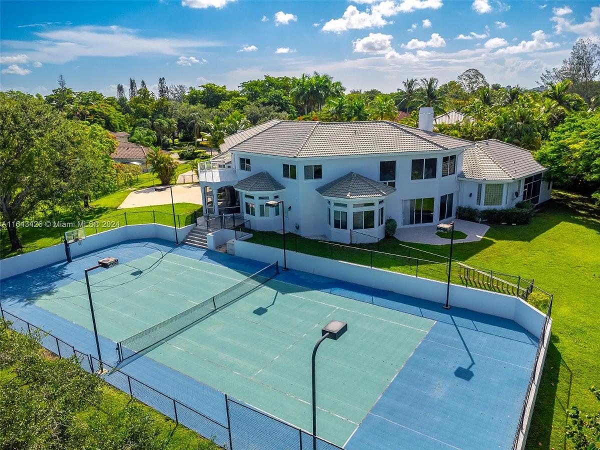 Aerial rear view of the mansion with a sport court.