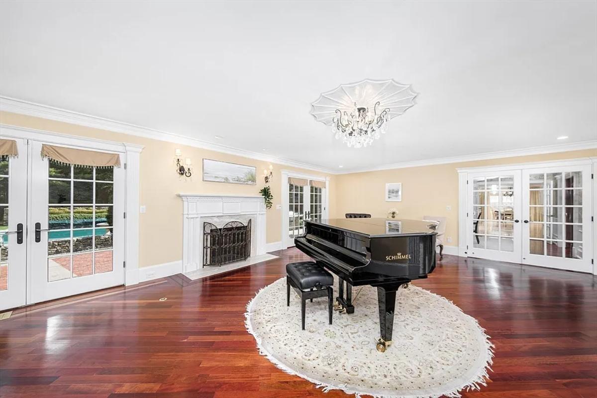 Piano room with hardwood floors and a fireplace.