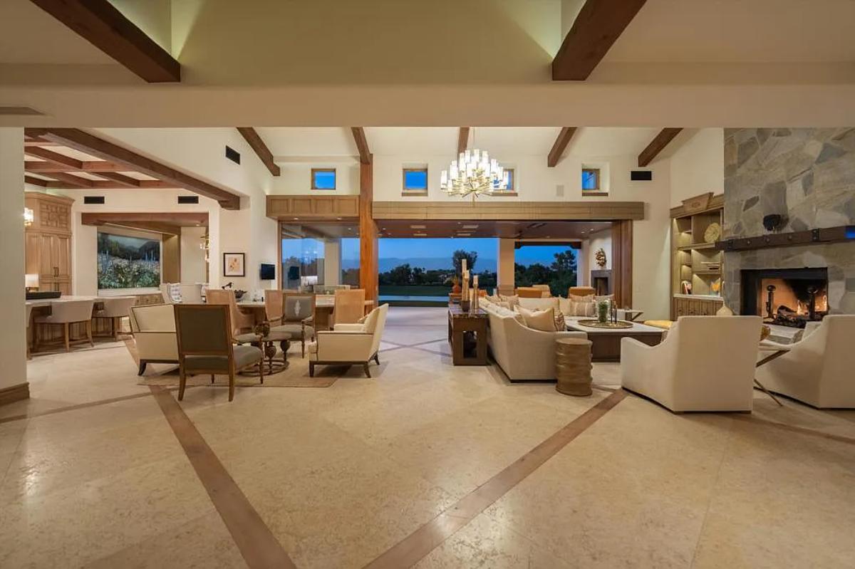 Living room with couches, vaulted ceilings and a fireplace.
