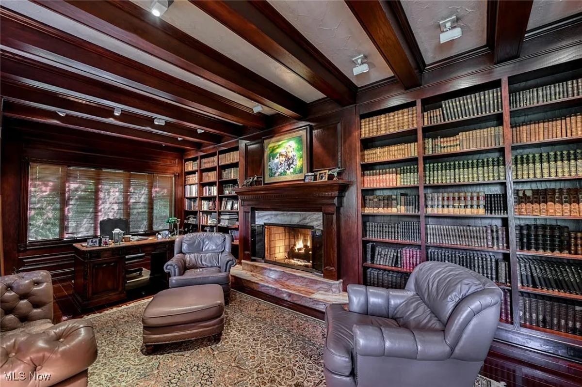 Home office with couches, fireplace and bookshelves.