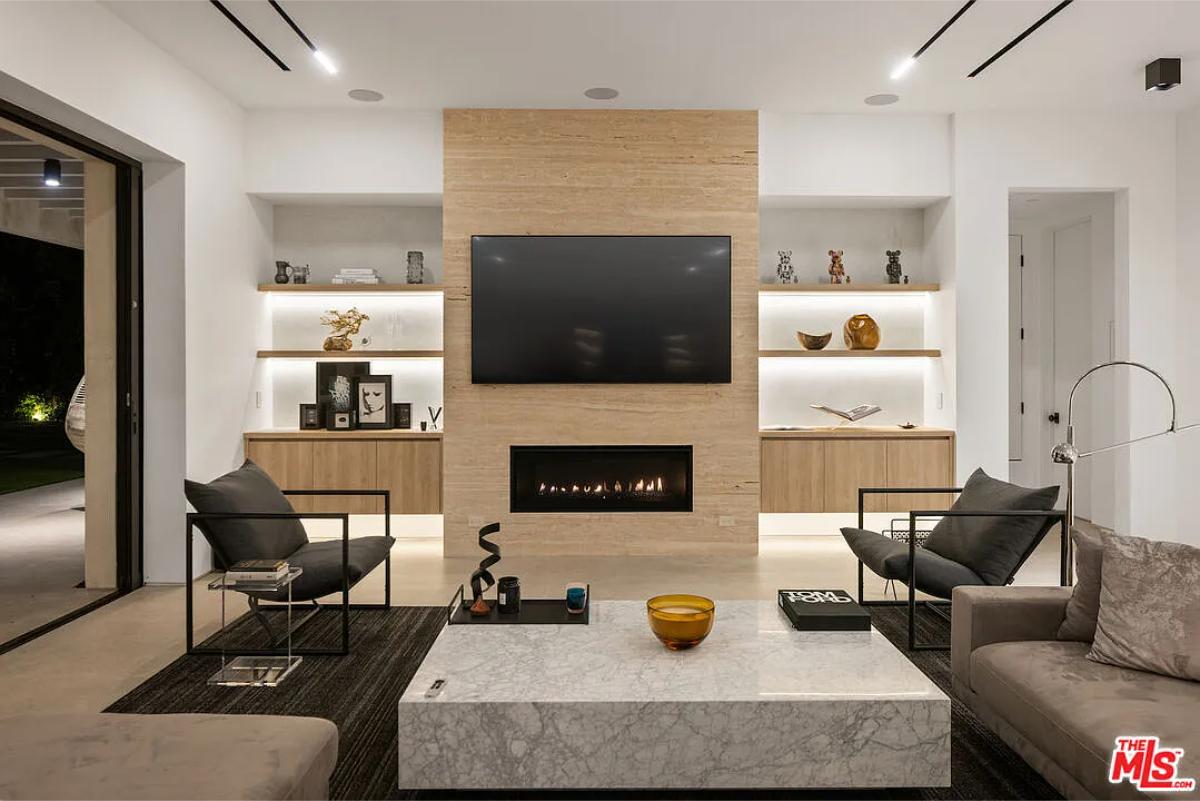 Living room with couches, TV and a fireplace.