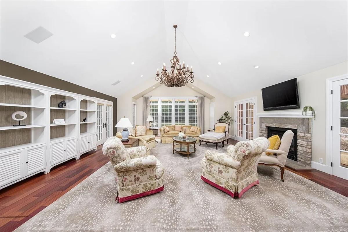 Living room with couches, a chandelier and a fireplace.