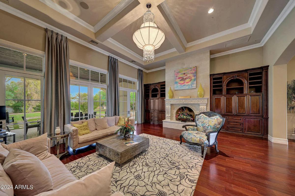 Living room with couches, chandelier and a fireplace.