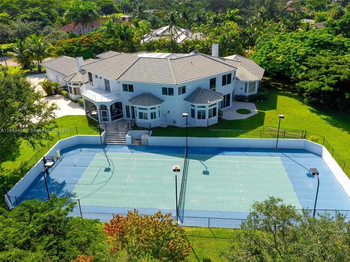 Aerial rear view of the mansion with a sport court.