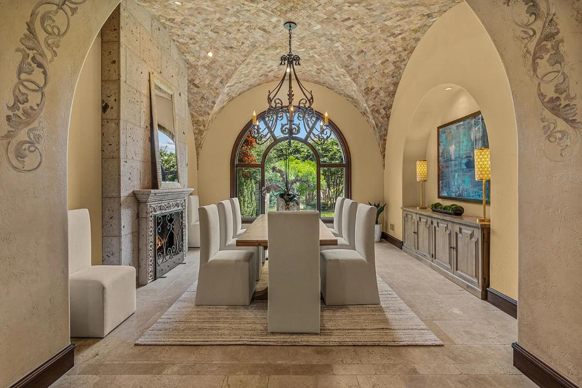 Dining room with a chandelier and a fireplace.
