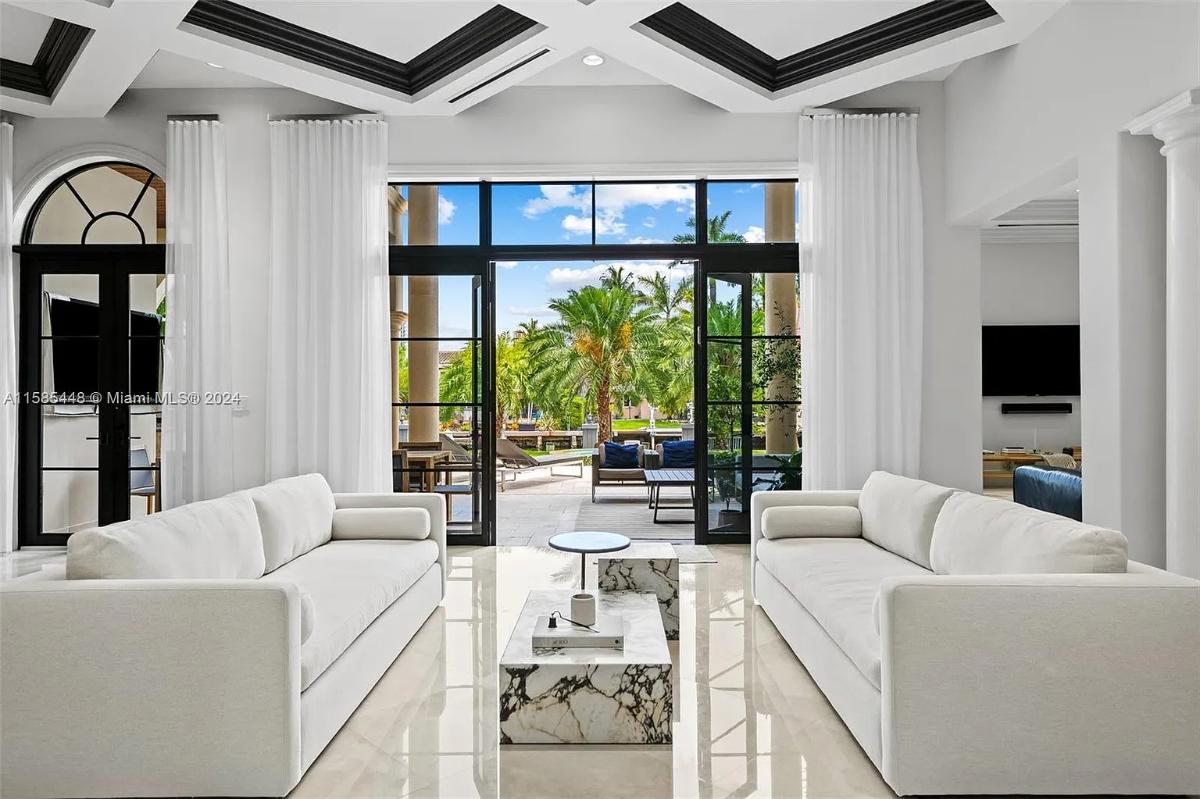 Living room with couches and marble floors.