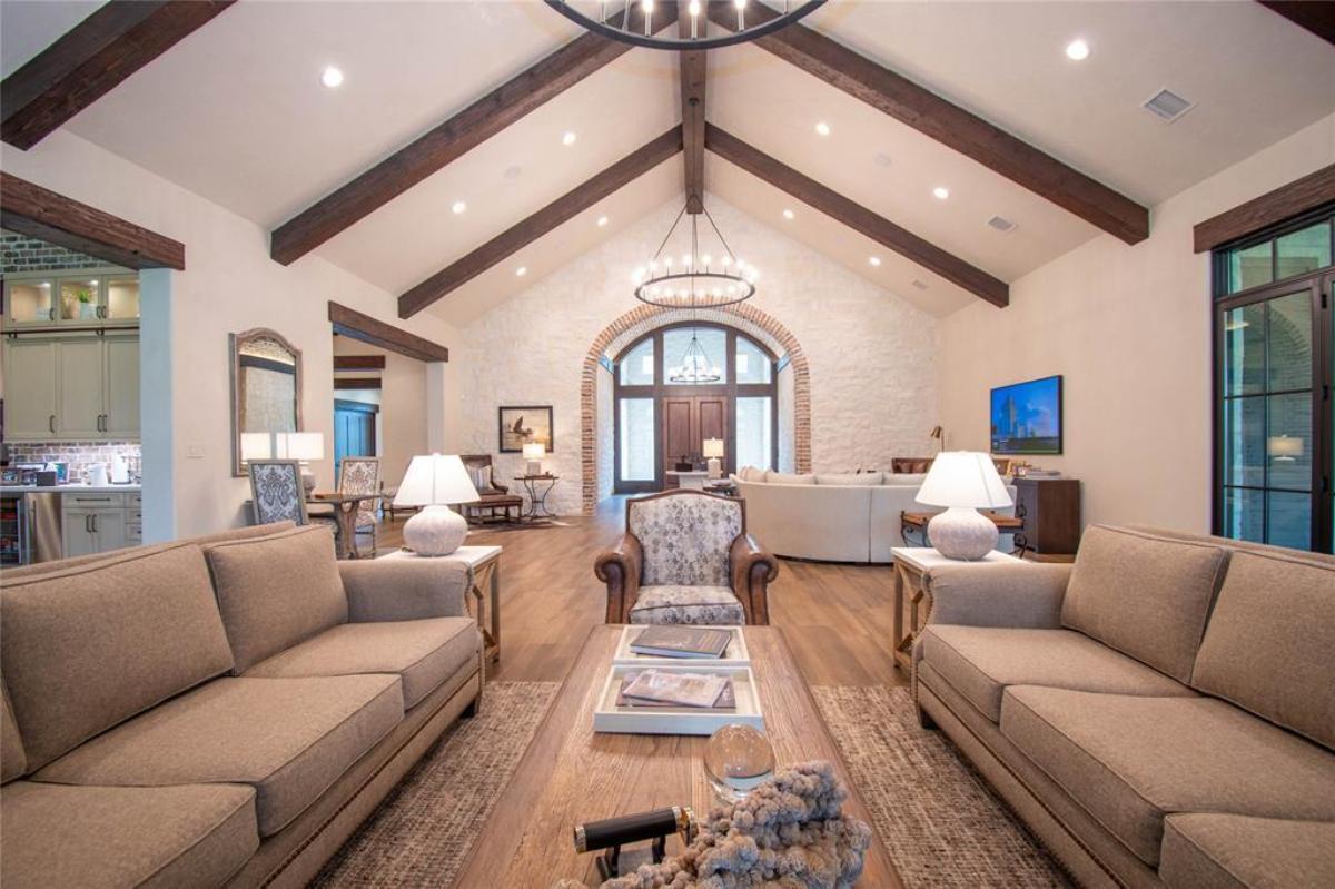 Living room with couches and hardwood flooring.