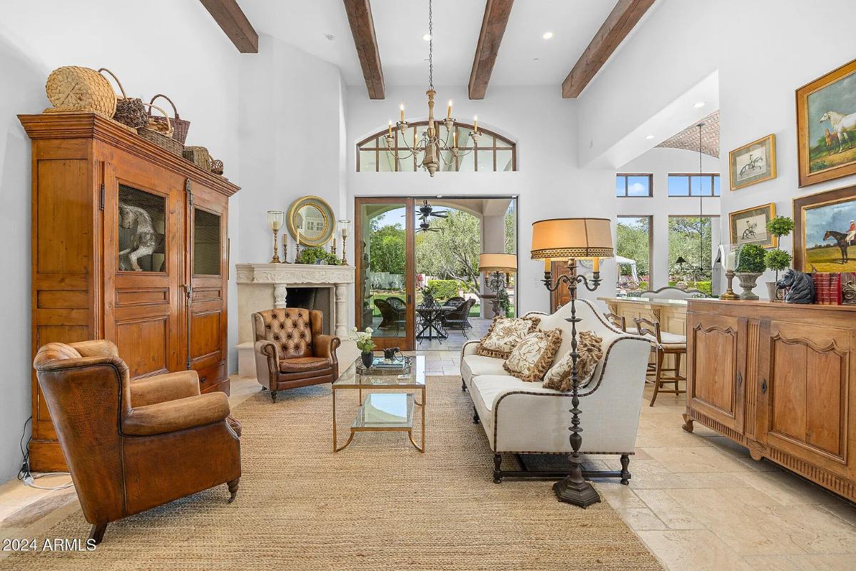 Living room with couches, glass doors and a fireplace.