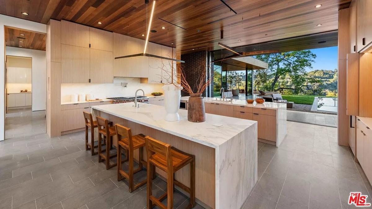 Kitchen with custom cabinetry, a counter breakfast bar and an island prep area.
