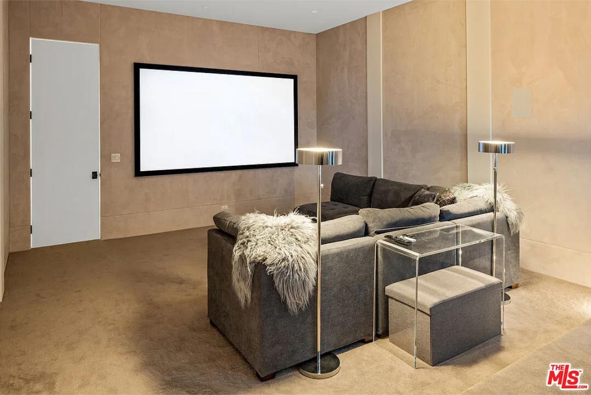 Home theater with couches and carpet flooring.