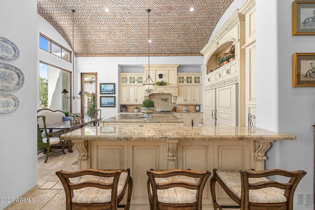 Kitchen with custom cabinetry, a counter breakfast bar and a center island prep area.