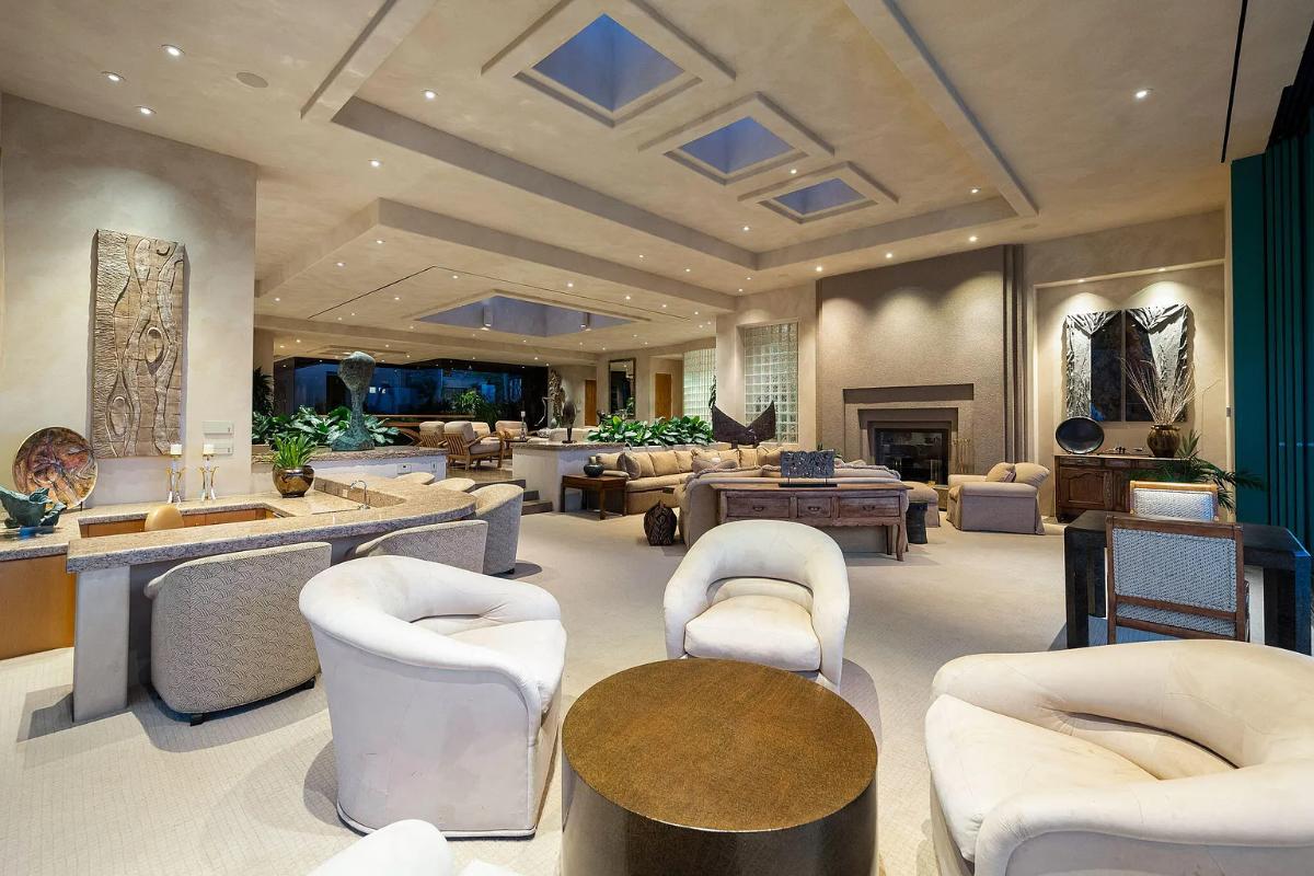 Living room with couches, carpet flooring and a fireplace.
