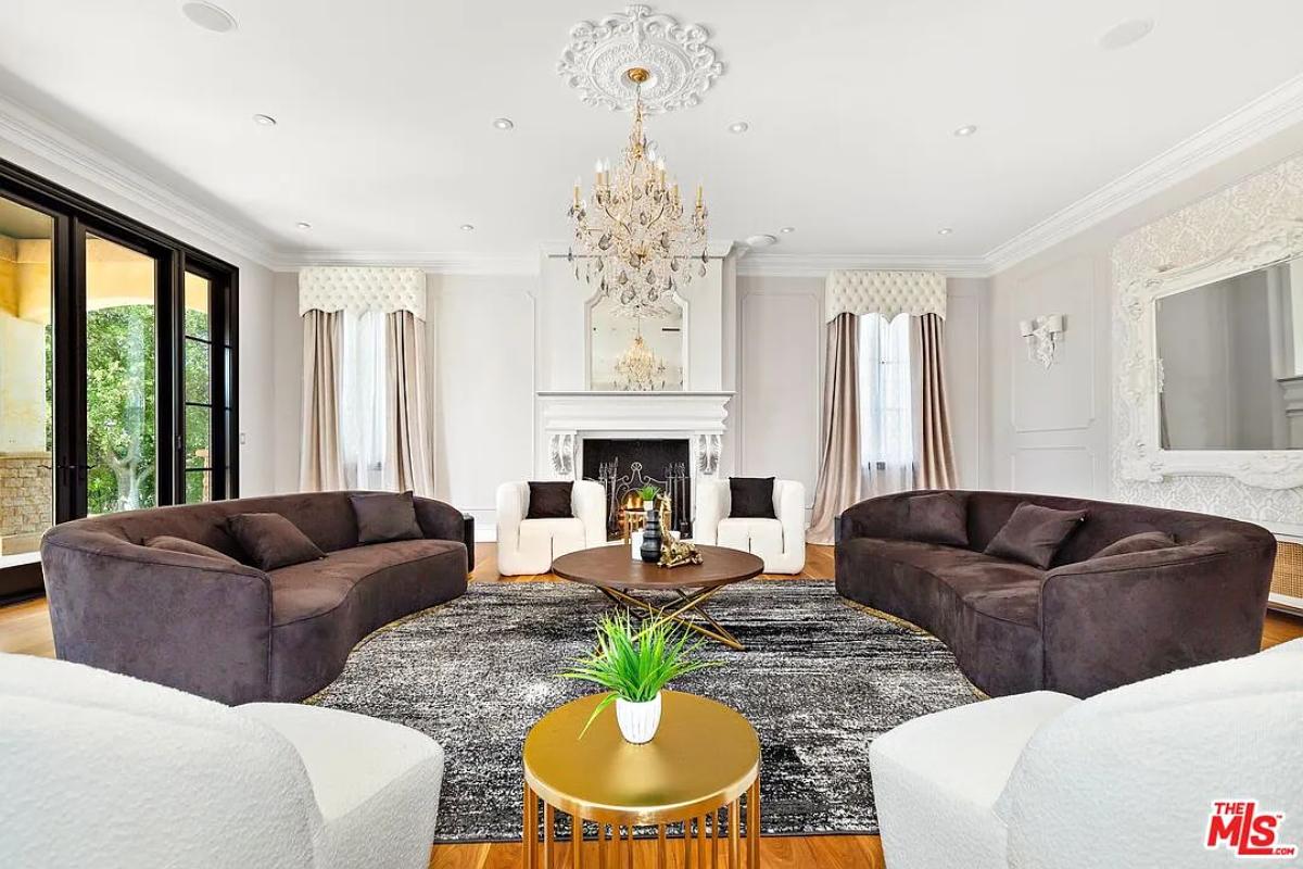 Living room with couches, a chandelier and a fireplace.