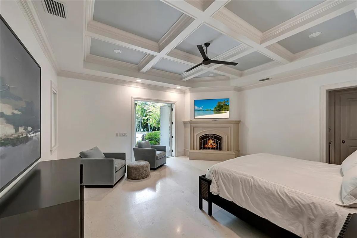 Bedroom with a large bed and a fireplace.