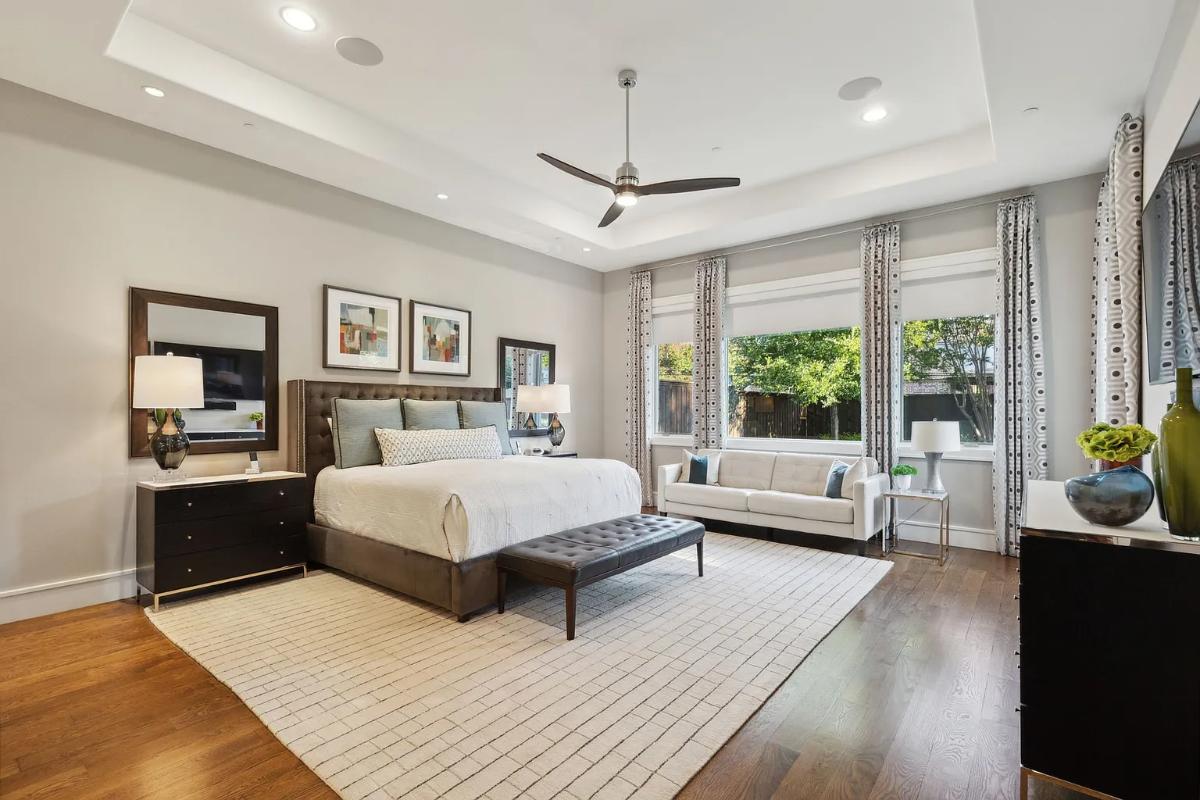Bedroom with a large bed, glass windows and hardwood floors.
