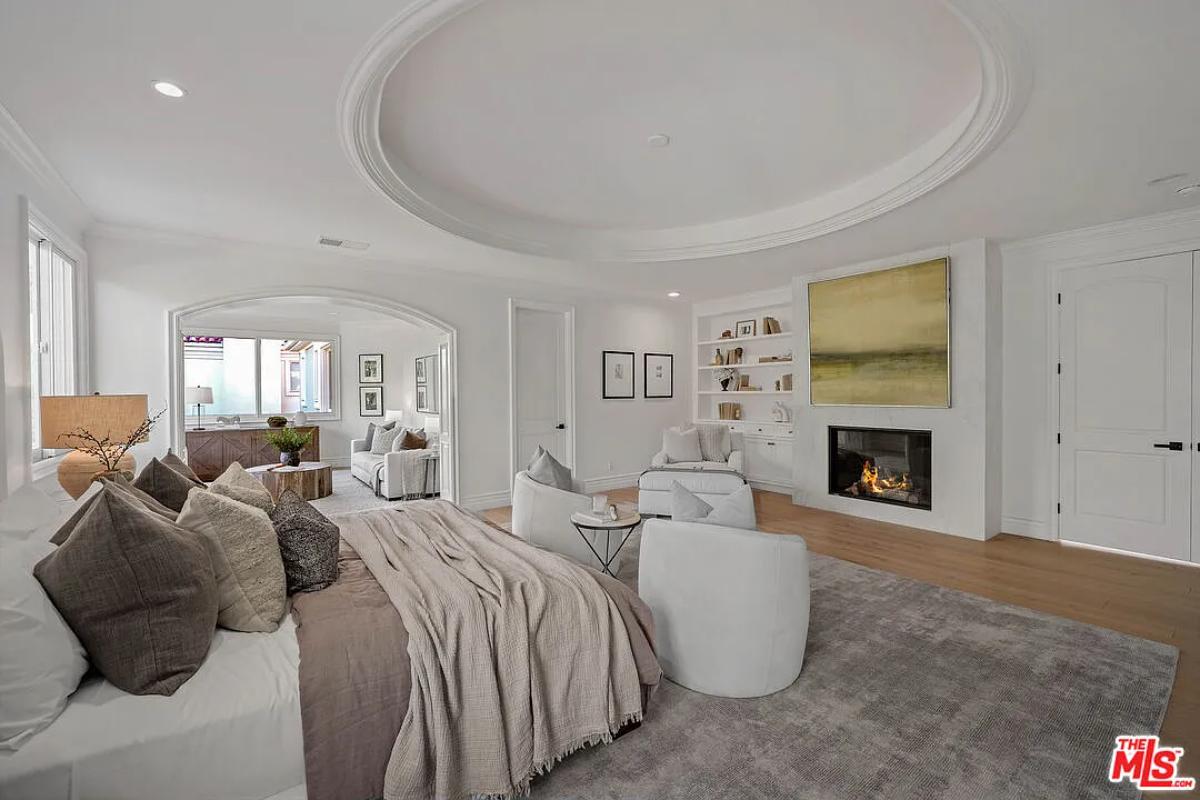 Bedroom with a living space and a fireplace.
