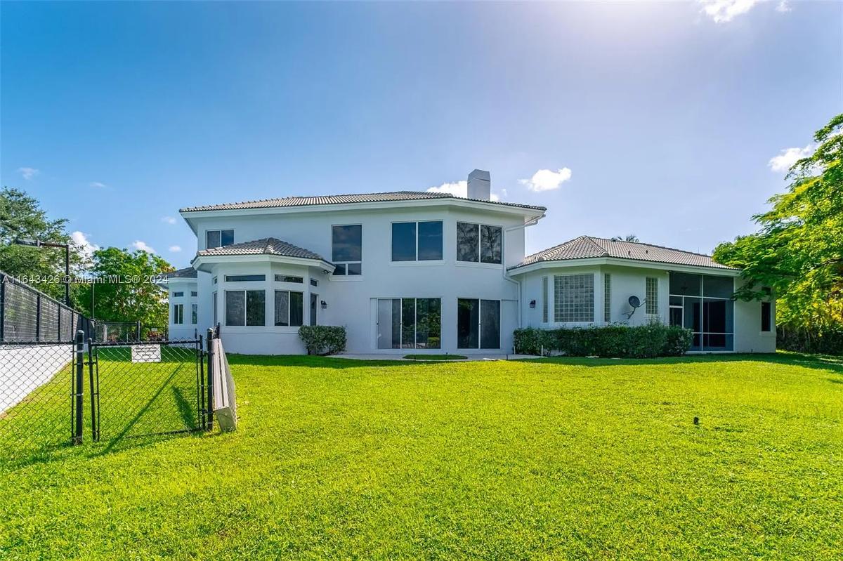 Rear view of the mansion with a large green lawn.