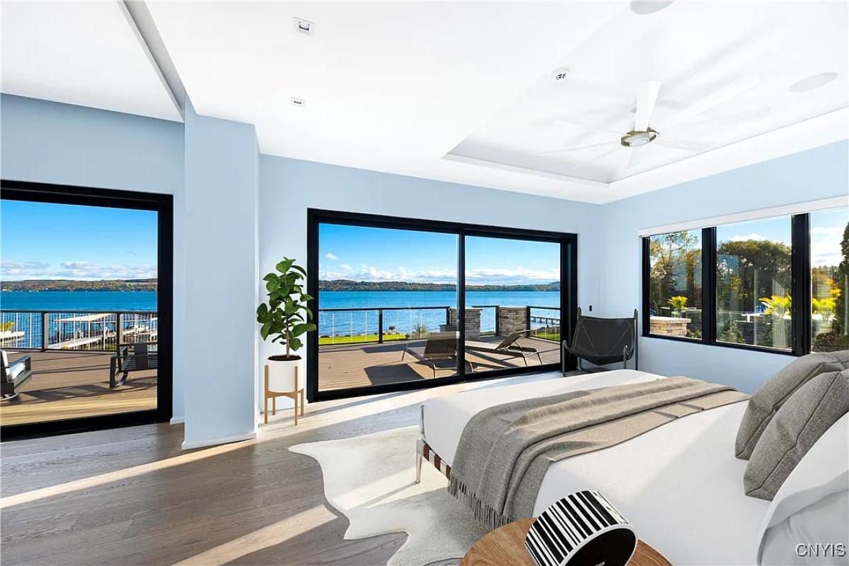 Bedroom with a large bed, sliding glass doors and hardwood floors.