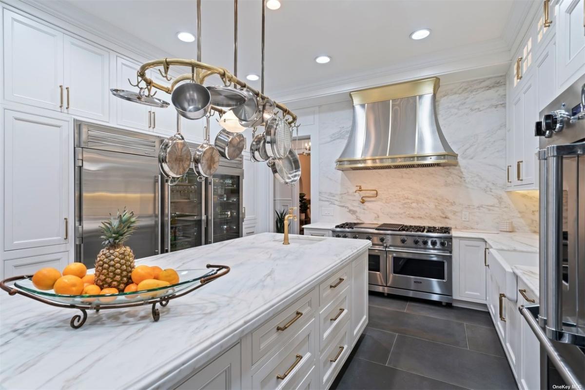 Kitchen with custom cabinetry, stainless-steel appliances and a center island prep area.