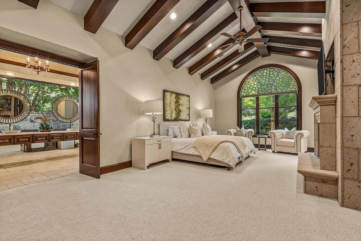 Bedroom with a large bed, vaulted ceilings and carpet flooring.