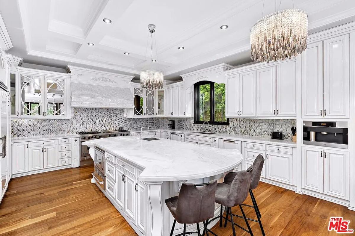 Kitchen with custom cabinetry, chandeliers and a center island prep area.