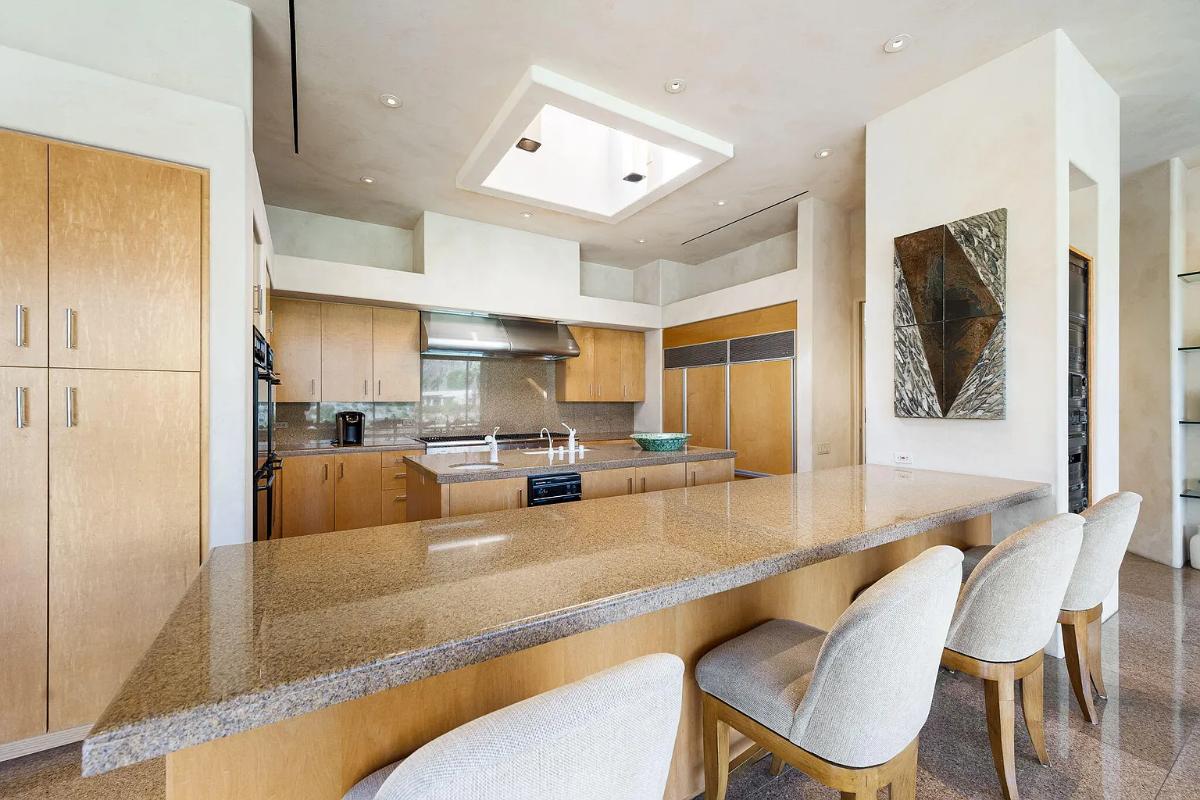 Kitchen with custom cabinetry, a counter breakfast bar and a center island prep area.
