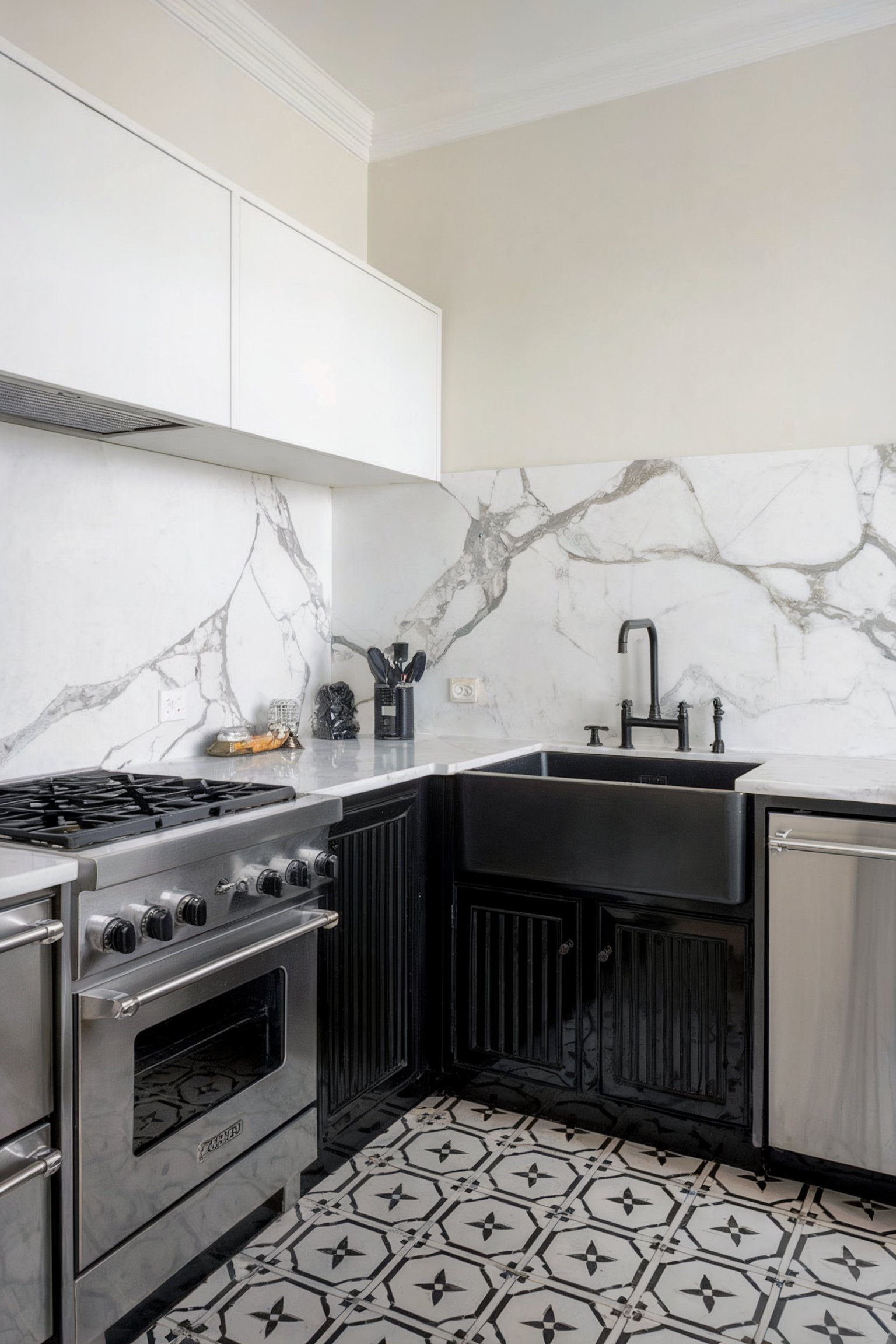 A kitchen featuring a marble backsplash with grey veining, black cabinets, a black farmhouse sink, and stainless steel appliances