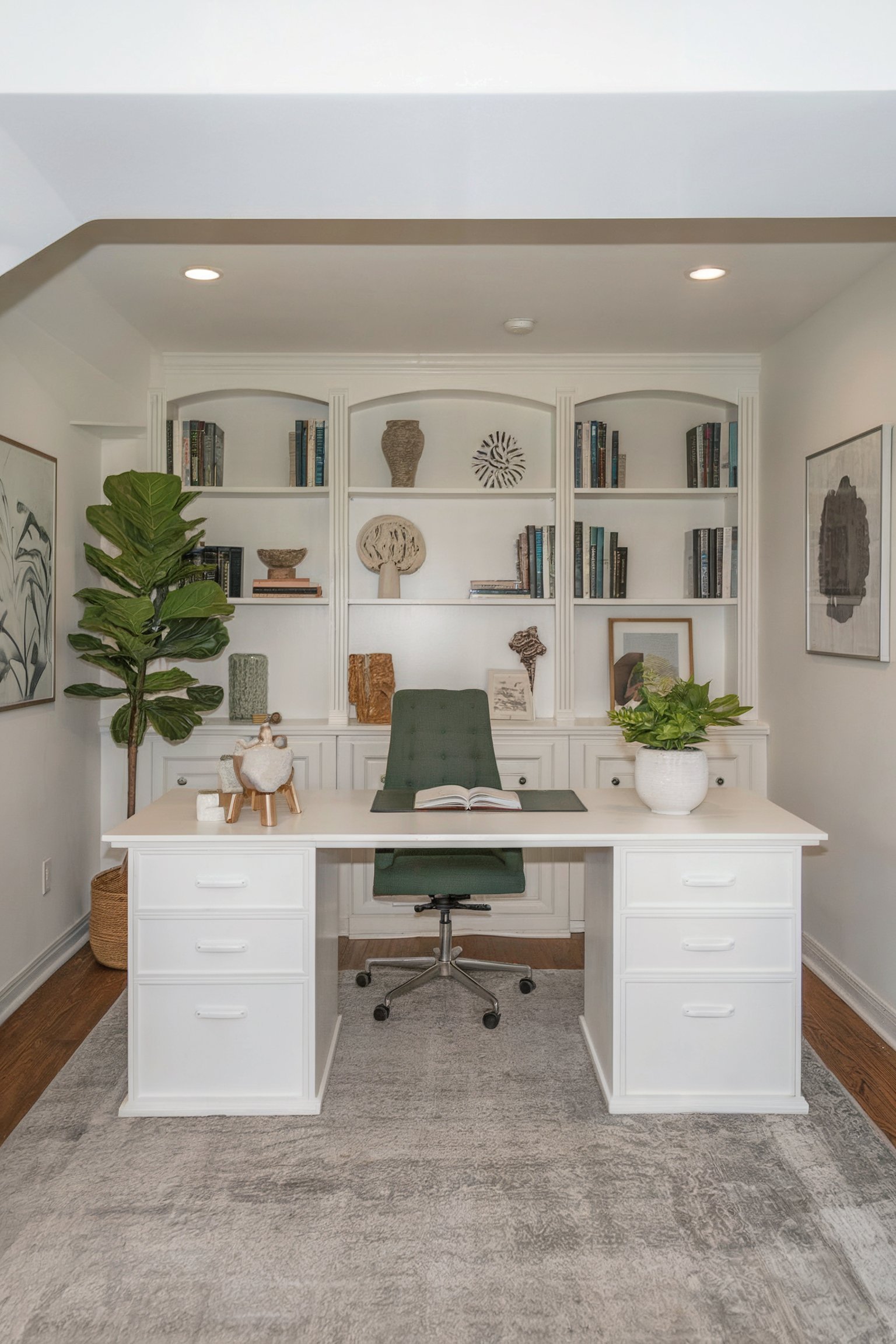 A stylish basement office with white built-in bookshelves, a modern desk, and green plants adding a fresh touch