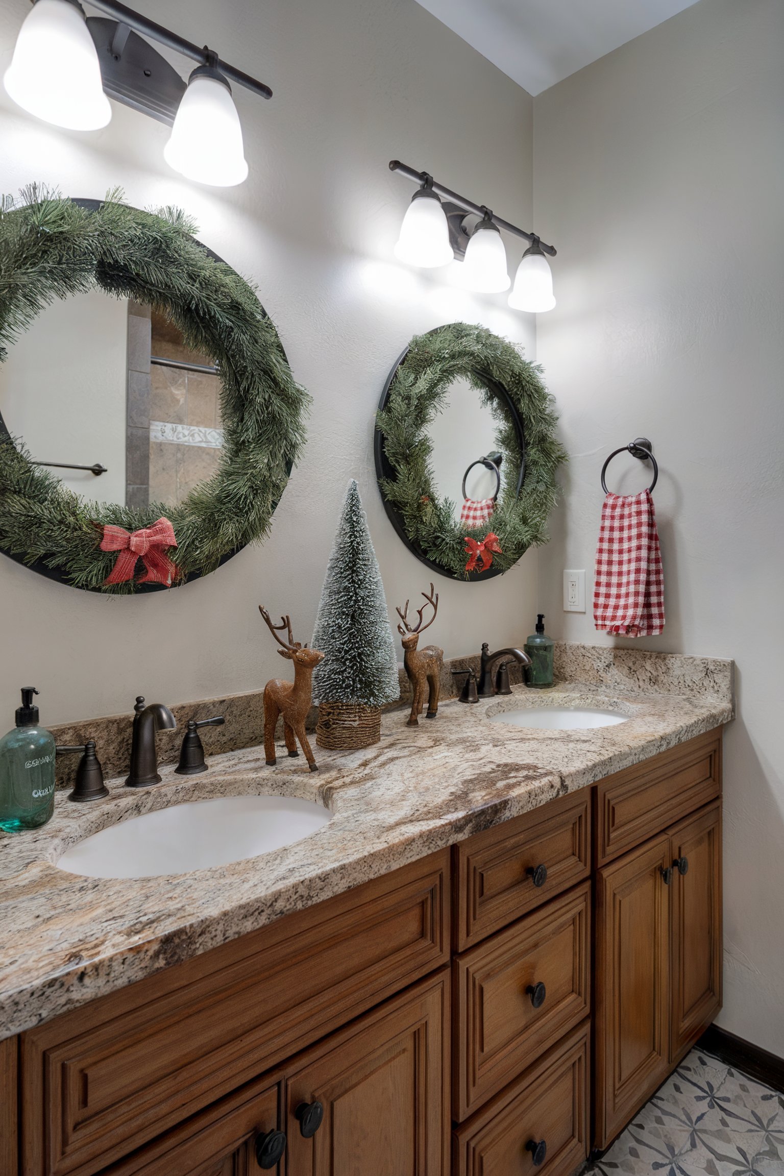 Bathroom vanity with mirrors framed by Christmas wreaths, reindeer figurines, and a small frosted tree