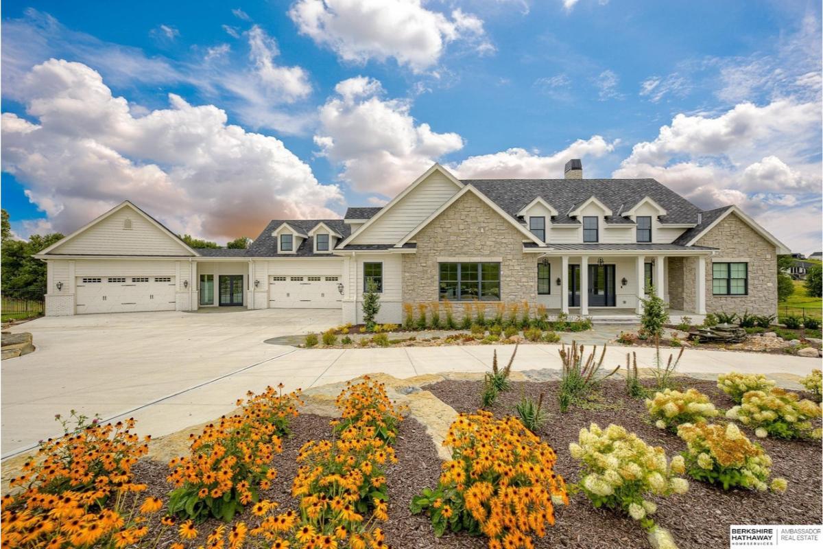 Expansive Front Yard with Lush Gardens and Classic Stone Facade