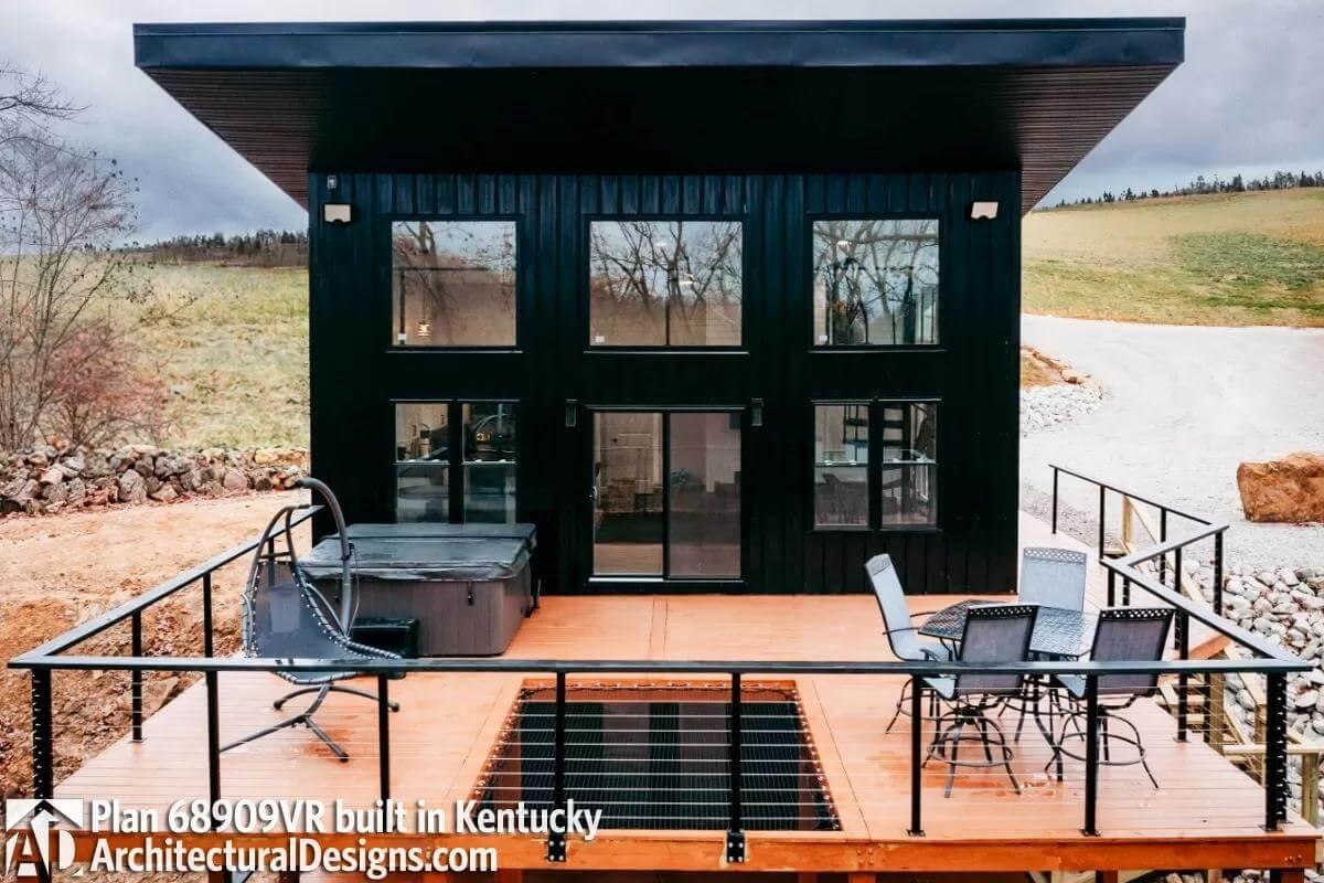 Modern Cabin with Sleek Black Facade and Inviting Deck