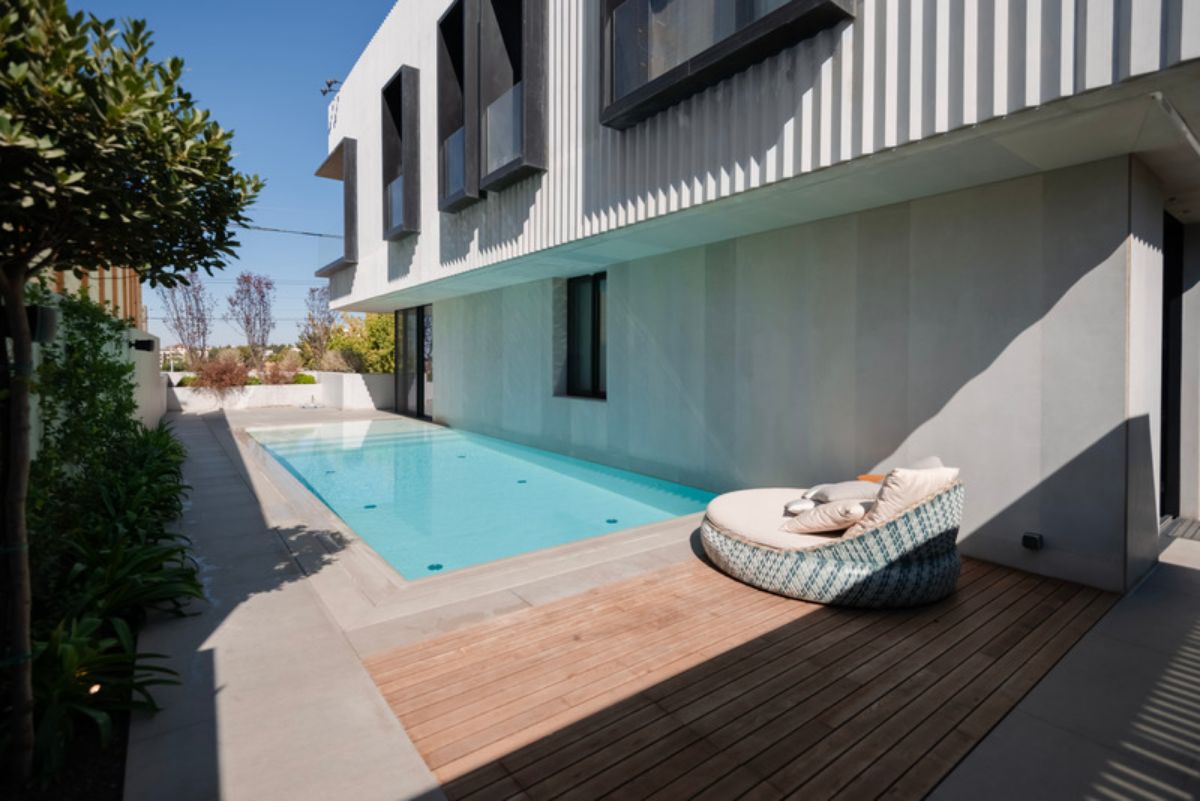 Rectangular pool just beside the house with a pool lounge chair