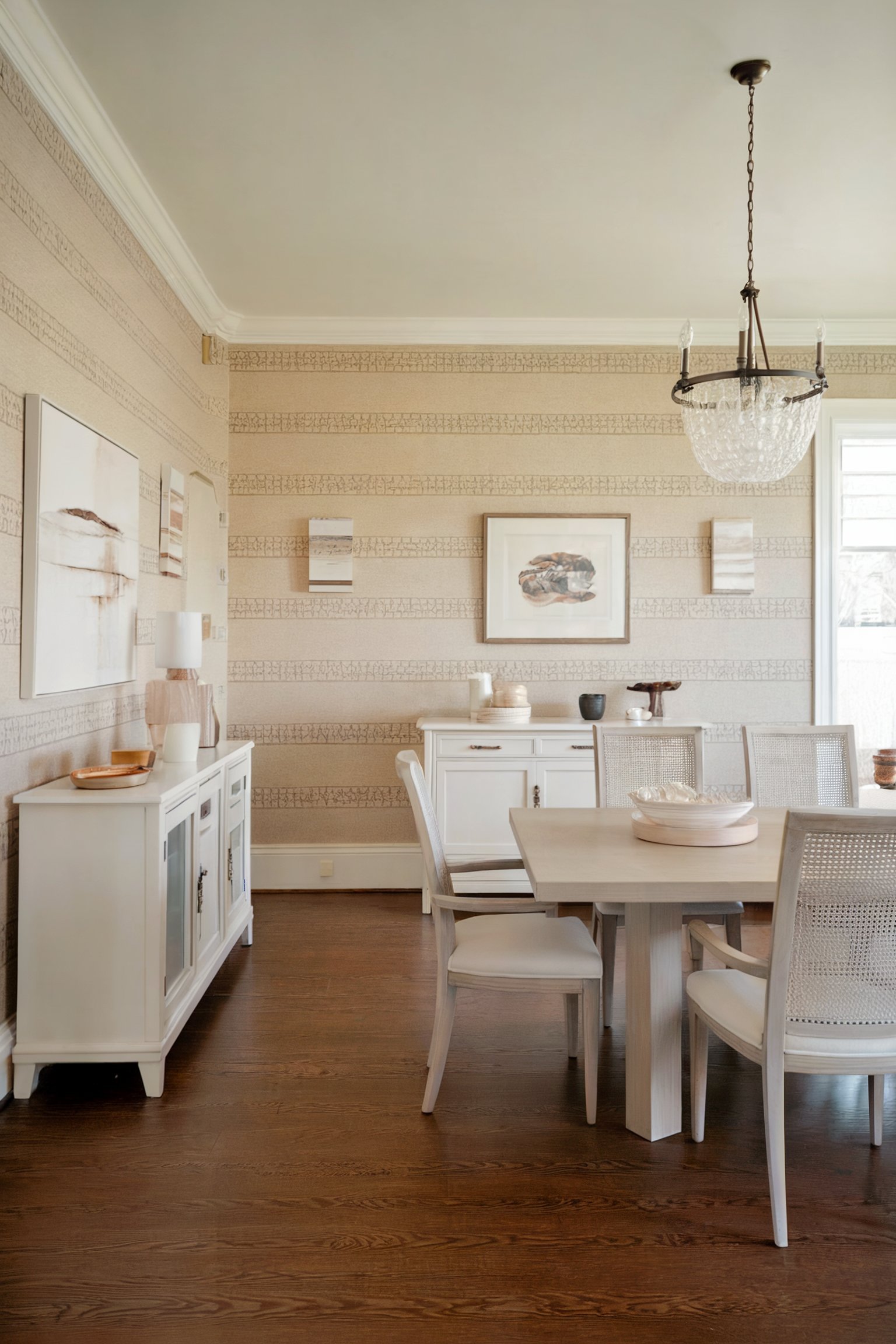 Light, airy dining room with beige wallpaper, white furniture, and minimalist wall art