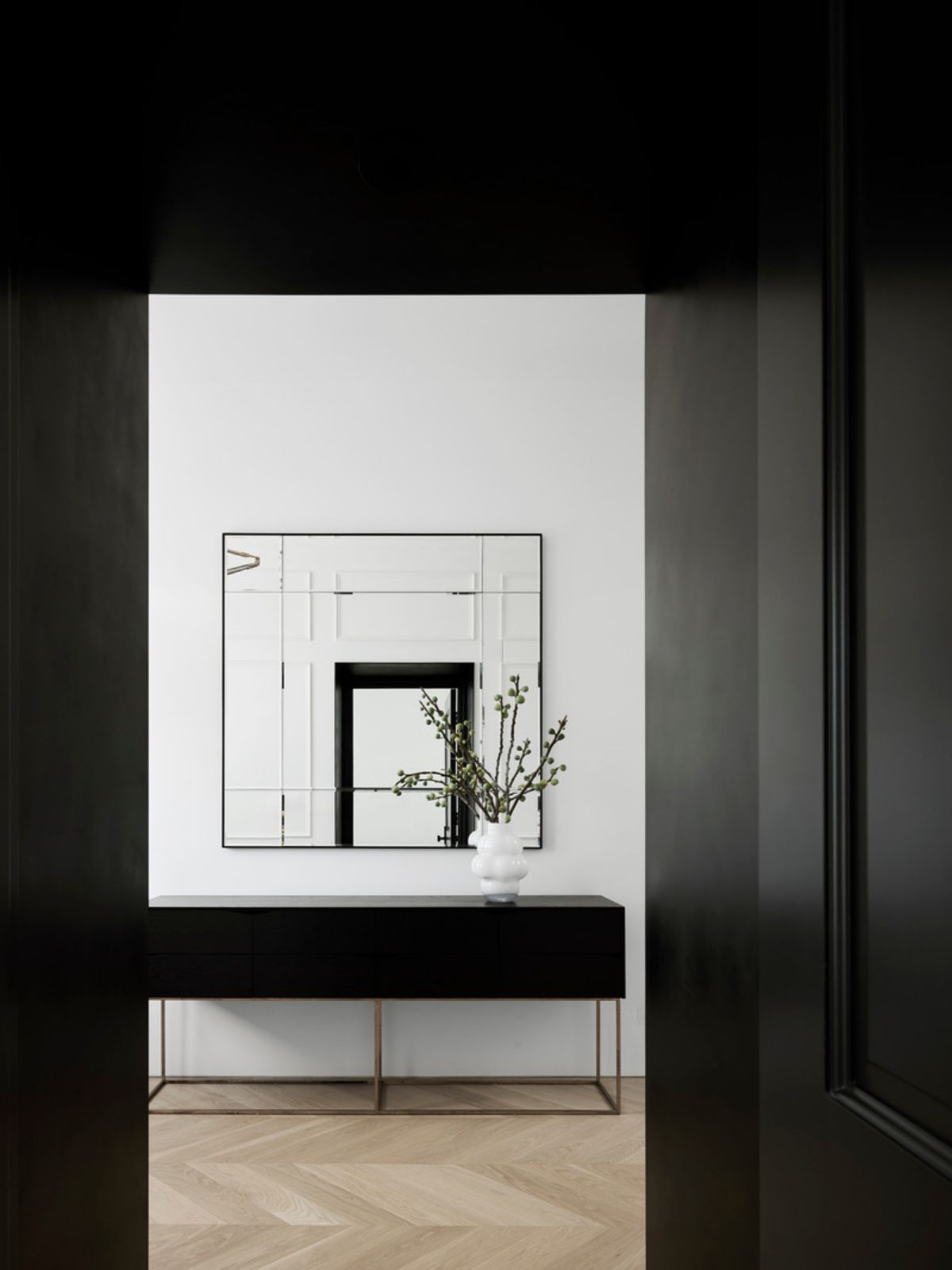 In the powder room, the faucet in satin bass finish from Watermark hovers over the black quartz countertop.