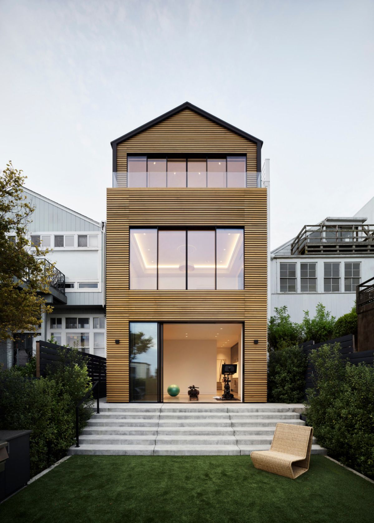 The reimagined rear façade features custom Western Red Cedar and oversized glazed units, including glass doors from Orama Minimal Frames