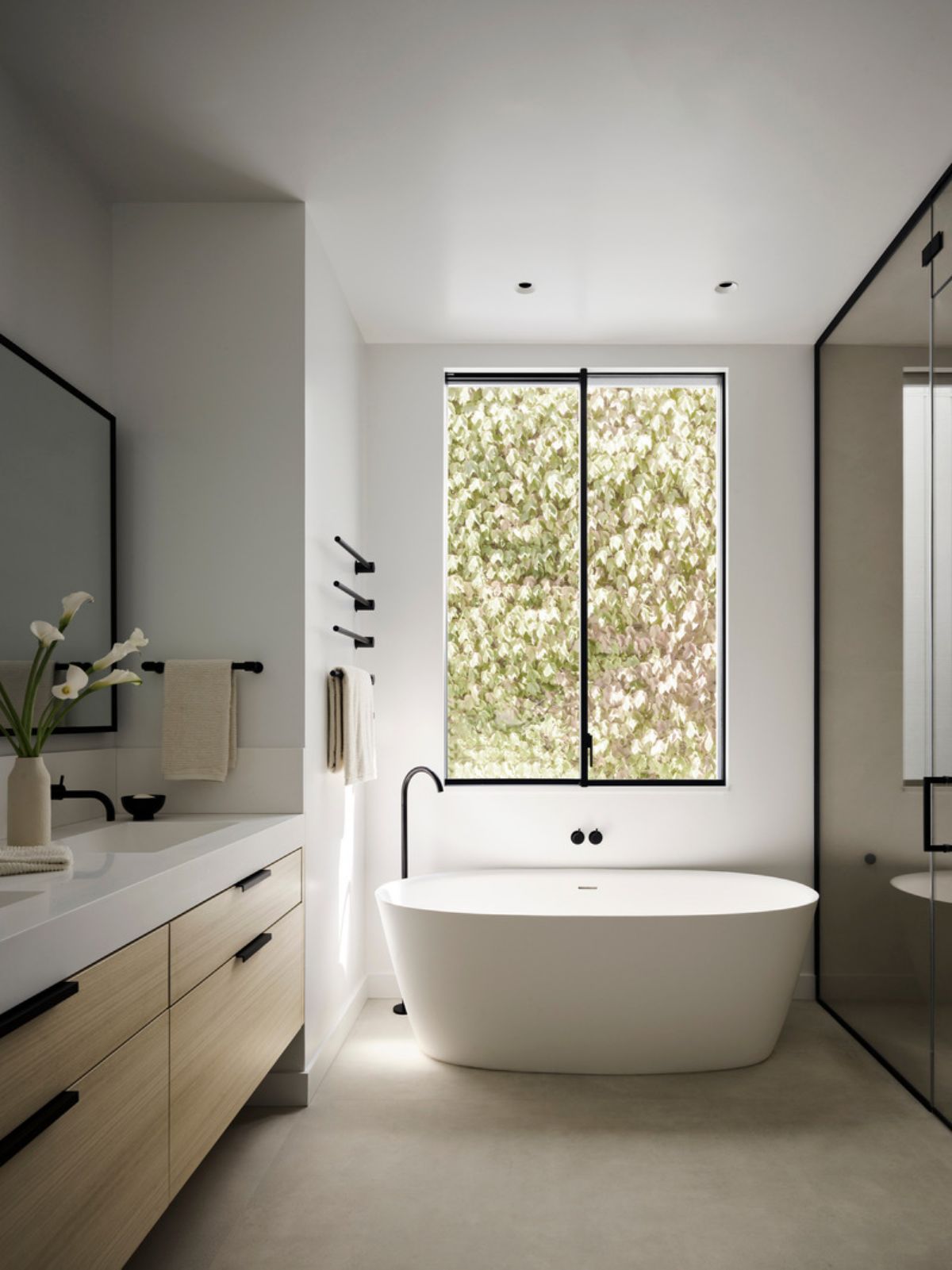 The primary bathroom features custom cut porcelain slab floor and walls from Laminam.