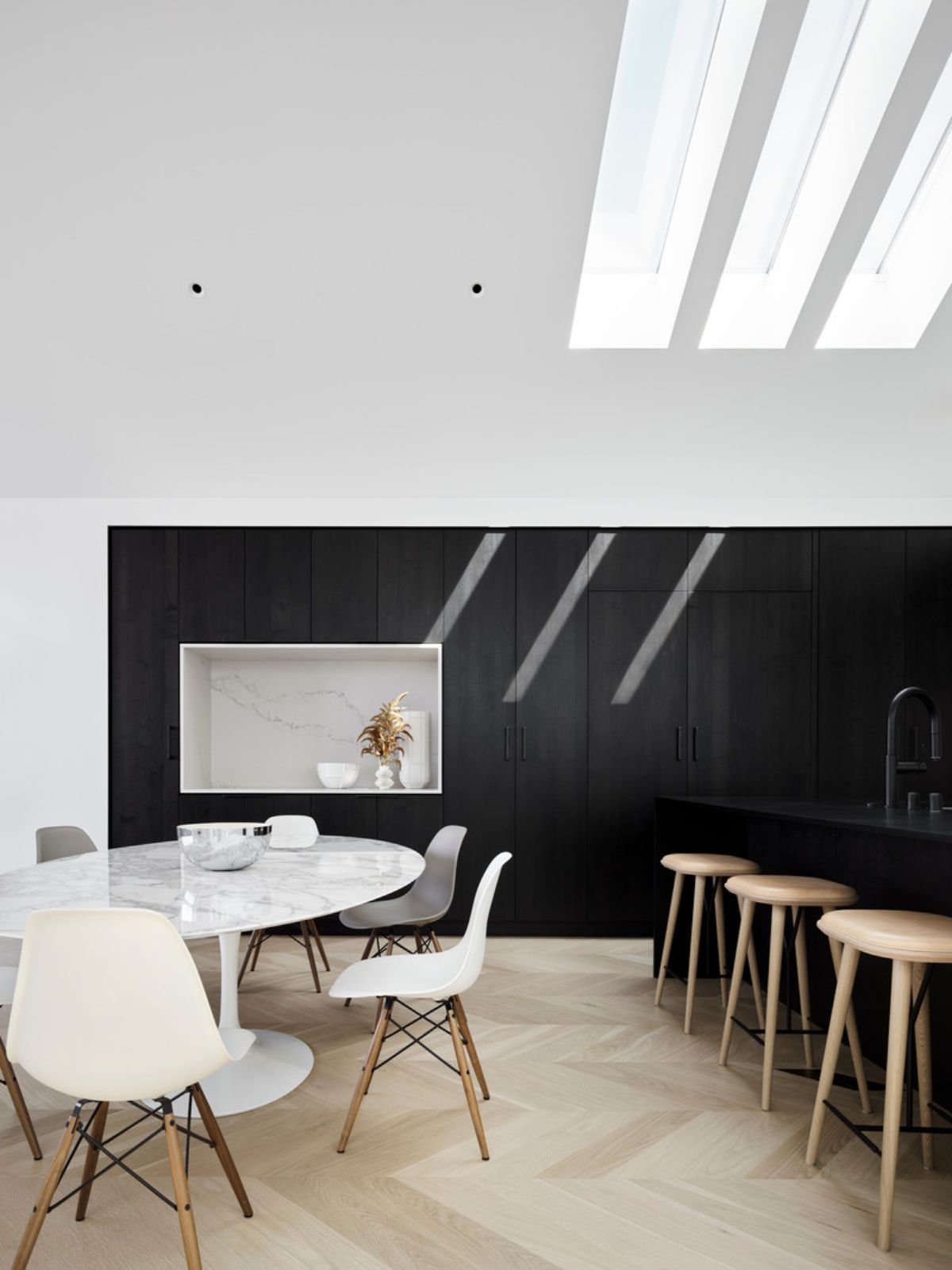 Natural light from the horizontal skylights washes over the dining area.