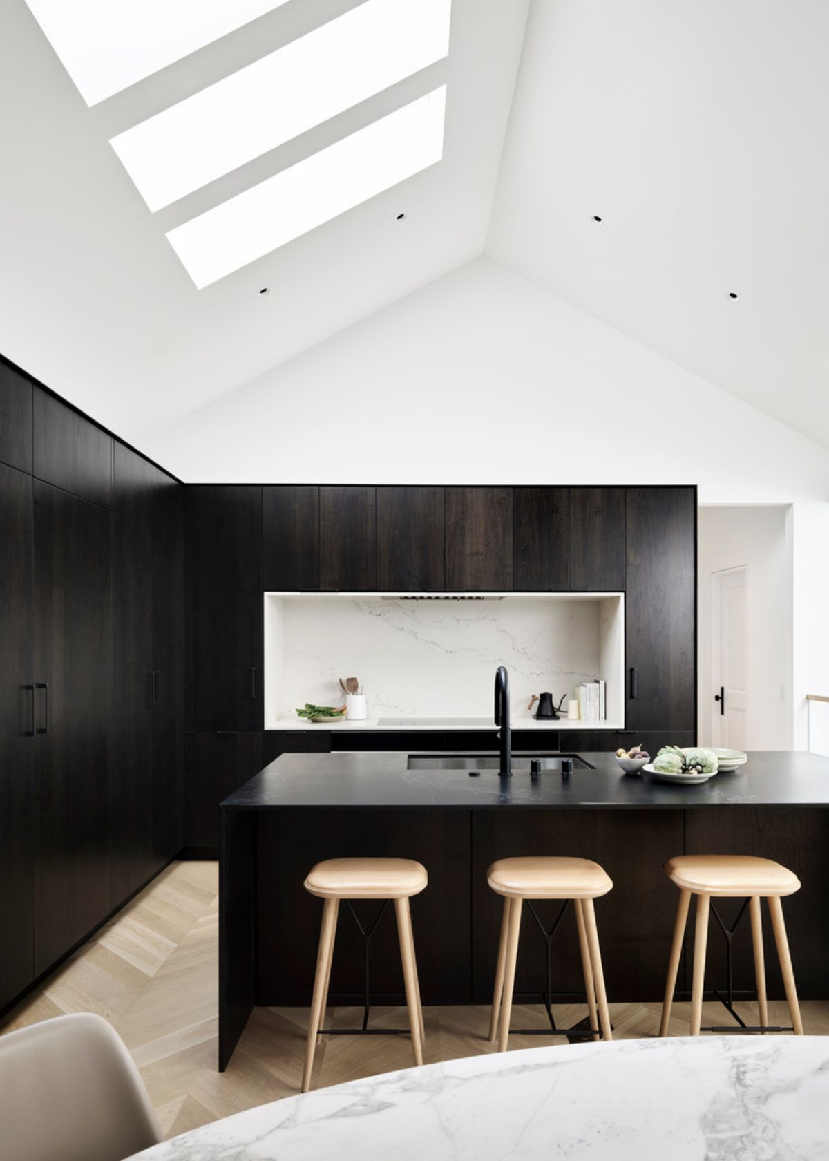 The kitchen appliances include a cooktop, hood liner and oven from Wolf. On the island, the stainless steel sink is from Rohl and the pull-down faucet is from Graff.
