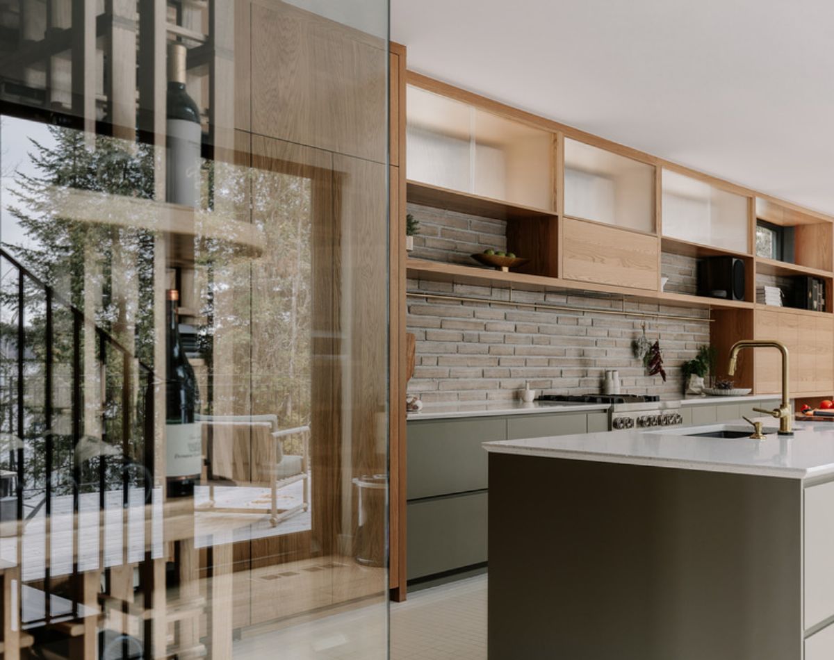 Kitchen area with a glass-enclosed wine cellar, hanging cabinets and kitchen island