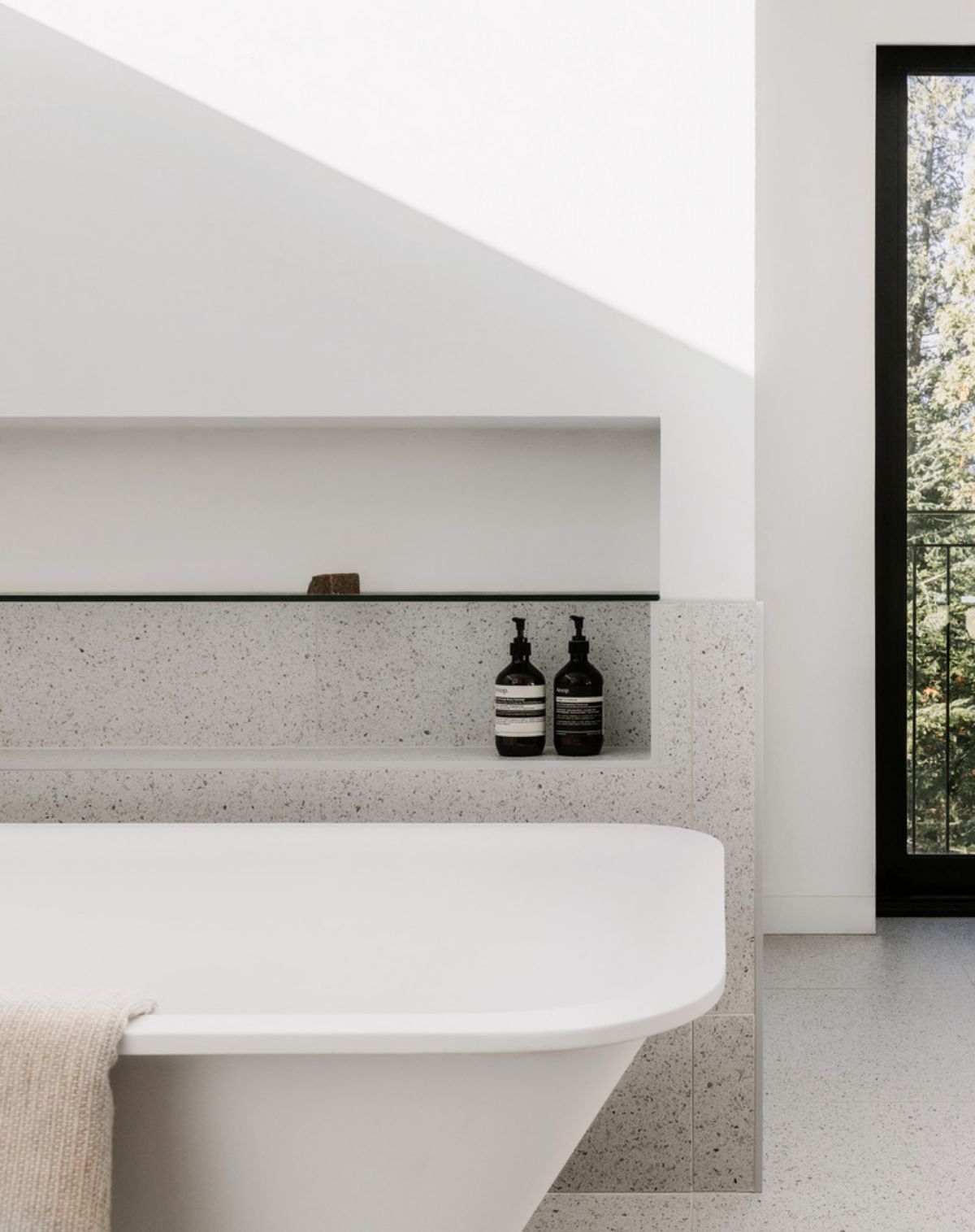 Bathtub and glass doors allowing natural light to filter