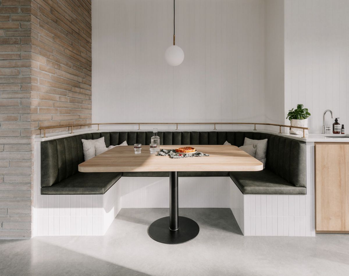 Dining table with sofa and round hanging light bulb