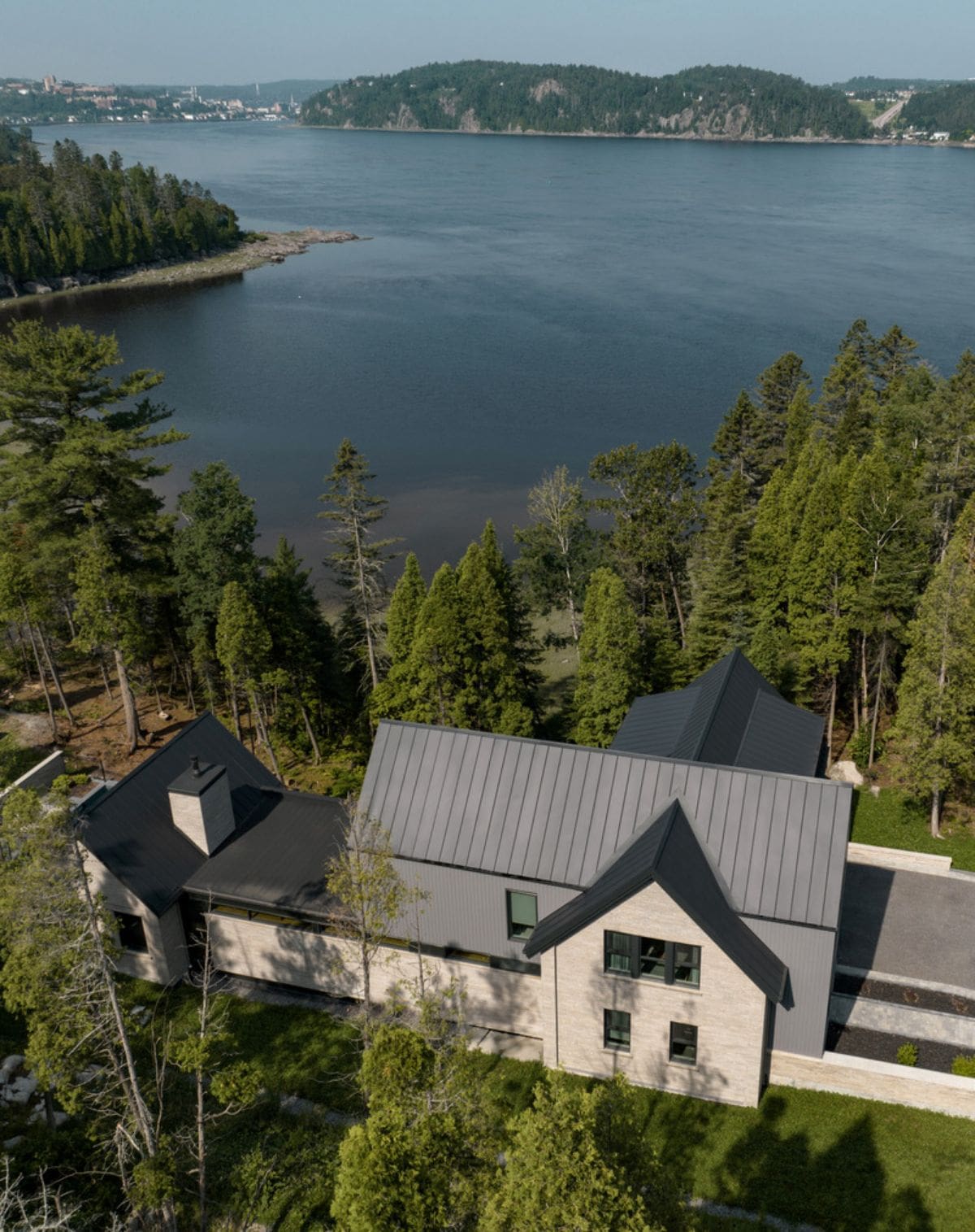 Aerial view of the house surrounded by lush nature and near the fjord