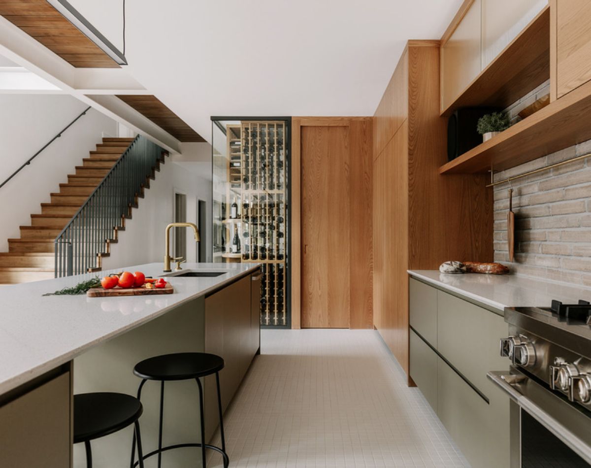 A glass-enclosed wine cellar facing a wide staircase