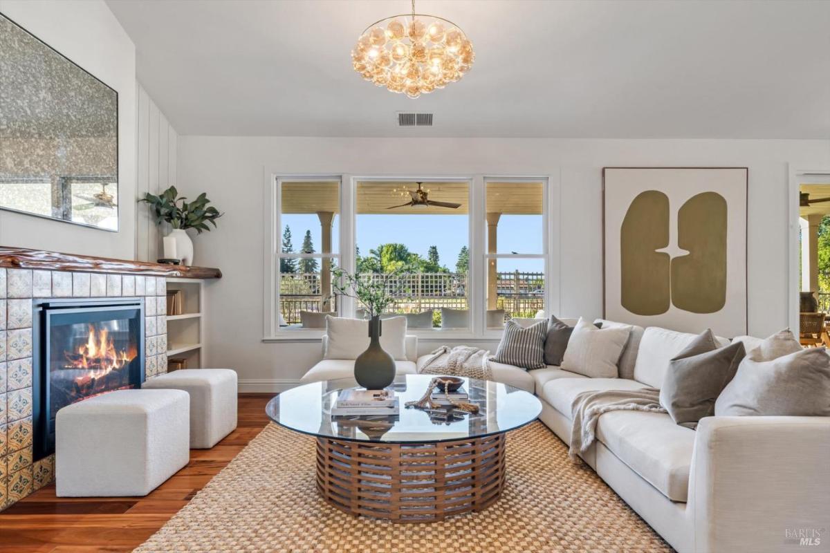 Family room with a fireplace, sectional sofa, and large windows overlooking a patio.