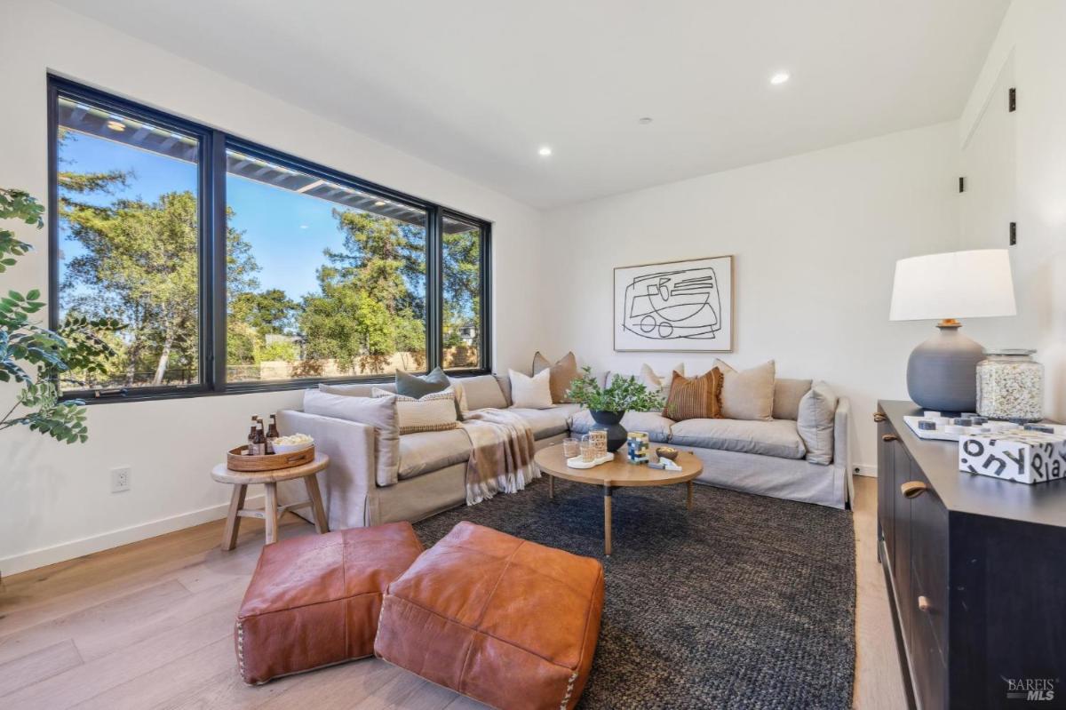 Family room with a sectional couch and windows.