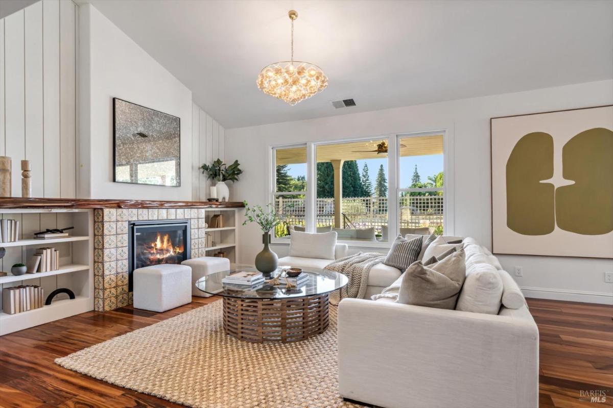 Family room showing the fireplace, built-in shelves, and a glass coffee table.