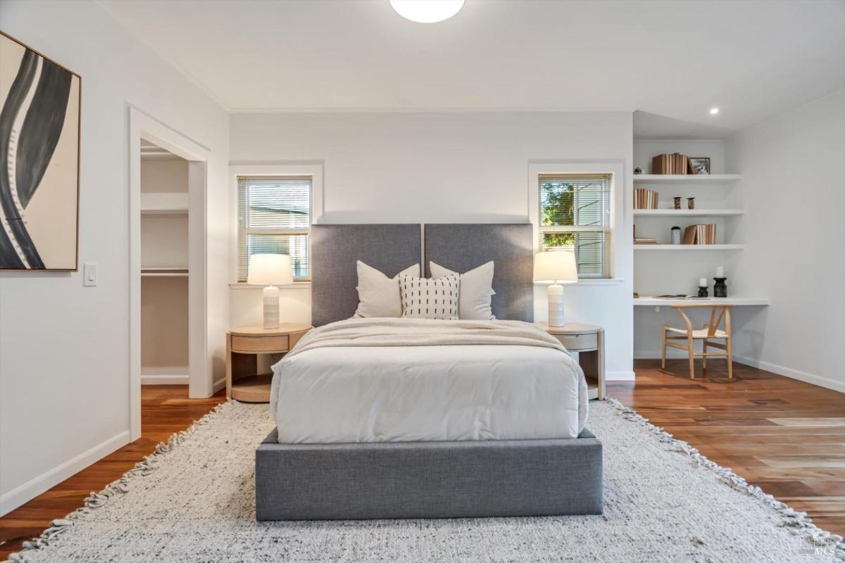 Bedroom with a bed, nightstands, and built-in shelves next to a desk.