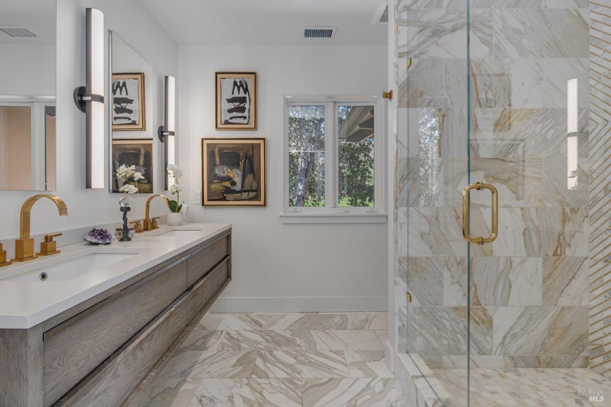 Bathroom with a glass shower, double sinks, and decorative accents.
